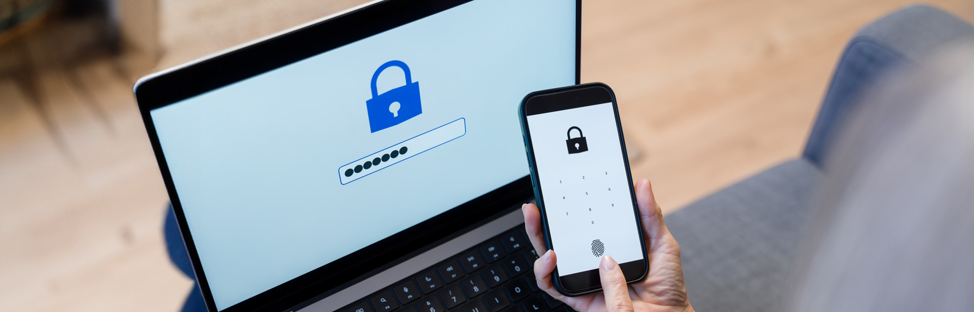 Person using two-factor authentication with a smartphone and laptop displaying lock icons and password fields.