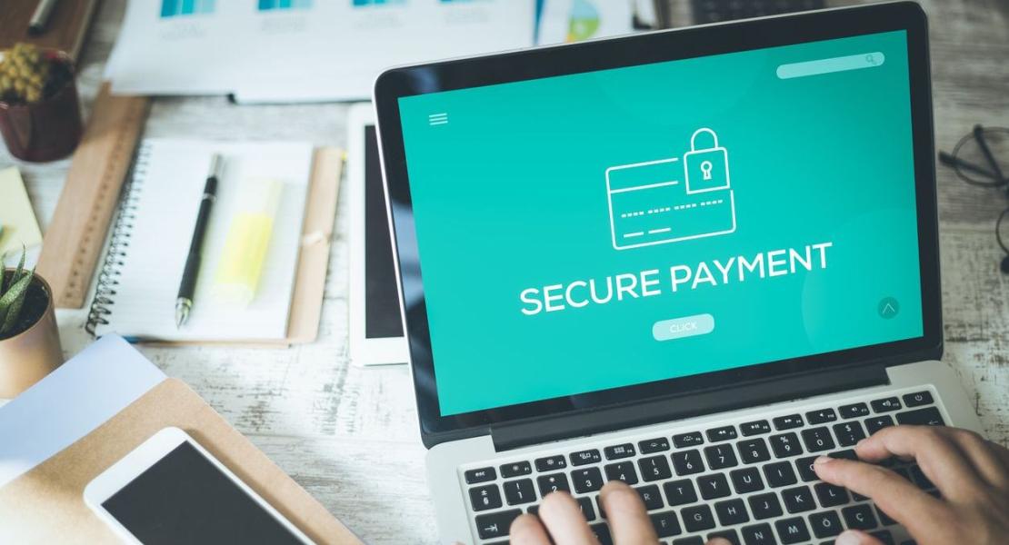 Une personne tapant sur un ordinateur portable affichant un écran de Paiement Sécurisé, mettant en avant la sécurité des transactions en ligne